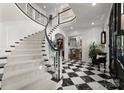 Beautiful foyer with a curved staircase and black and white checkered floors at 131 The Point Dr, Mooresville, NC 28117