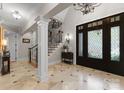 Elegant foyer with marble floors, a decorative front door, and a staircase leading to the upper level at 13215 Claysparrow Rd, Charlotte, NC 28278