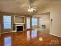 Open-concept living room with a cozy fireplace, hardwood floors, and natural light from multiple windows at 1420 28Th Sw St, Hickory, NC 28602