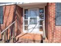 Close-up of the front door with glass panels, brick accents, and a small porch area at 1547 Kings Rd, Shelby, NC 28150