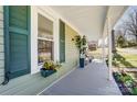 Charming covered front porch with decorative shutters, potted plants, and ample space for relaxation and outdoor enjoyment at 240 N Lackey St, Statesville, NC 28677