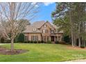 Charming brick home boasts a meticulously maintained lawn, mature trees and shrubbery, enhancing its curb appeal at 308 Covington Xing, Weddington, NC 28104