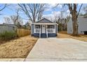 Charming exterior view of a home with a freshly poured concrete driveway and a cozy front porch at 343 Bell St, Mooresville, NC 28115