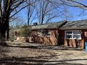 Brick home with a welcoming entrance, set among mature trees, with visible side driveway at 4073 Lee Cline Rd, Conover, NC 28613