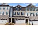 Three-story townhome exteriors boast stone accents, varied siding colors, and private one-car garages at 419 Burr St, Indian Trail, NC 28079