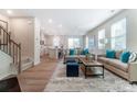 Open-concept living area with modern furnishings, hardwood floors, and seamless flow to the kitchen at 6419 Mallow Crossing Ln, Charlotte, NC 28213