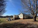 Exterior view of a home showcasing its backyard, including a small garage and side windows to the natural light at 7201 Gilead Rd, Huntersville, NC 28078
