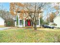 Traditional home exterior showing red door, mature tree, and meticulous landscaping at 8730 Rittenhouse Cir, Charlotte, NC 28270