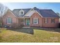 Traditional brick home with a tidy lawn, dormer windows, and an inviting covered front porch at 912 Silver Charm Ln, York, SC 29745