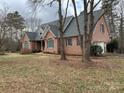 Charming brick home featuring dormer windows, a well-manicured lawn, and mature trees enhancing its curb appeal at 912 Silver Charm Ln, York, SC 29745