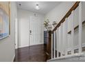 Inviting entryway featuring modern decor, a black cabinet and staircase with carpeted steps and wooden railing at 9804 Ainslie Downs St, Charlotte, NC 28273