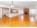 Open-concept living room with fireplace, hardwood floors, and view of updated kitchen at 1003 Oak Hill Dr # 24, Monroe, NC 28112