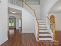 Spacious foyer with hardwood floors, staircase, and views into other living areas at 10032 Montrose Nw Dr, Charlotte, NC 28269