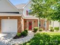 Welcoming front entrance with a red door, brick facade, and neat landscaping at 10032 Montrose Nw Dr, Charlotte, NC 28269