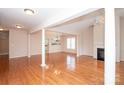Bright, open living room with gleaming hardwood floors, columns, and a cozy fireplace at 10034 Bishops Gate Blvd, Pineville, NC 28134