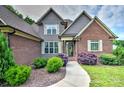 Inviting brick home entrance with beautiful landscaping and a paved walkway at 1011 Duntov Dr, Monroe, NC 28110
