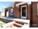 Close-up view of a brick home's front entrance featuring a white-trimmed glass door and canopy at 104 N 9Th St, Bessemer City, NC 28016