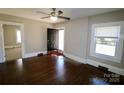Inviting living room with hardwood floors, neutral paint, bright windows, and classic ceiling fan at 104 N 9Th St, Bessemer City, NC 28016