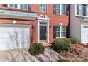 Close up of a charming two-story brick townhome with attached garage and black shutters at 128 S Arcadian Way, Mooresville, NC 28117