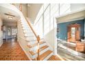 Bright foyer features hardwood floors, staircase to the upper level, and a view into the adjacent living spaces at 1321 Pennington Nw Pl, Concord, NC 28027