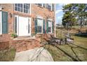 Inviting front porch featuring a cozy seating area, brick steps, and lush landscaping, perfect for relaxing outdoors at 1321 Pennington Nw Pl, Concord, NC 28027