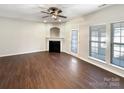 Spacious living room with a fireplace, hardwood floors, and a ceiling fan at 13811 Waverton Ln, Huntersville, NC 28078