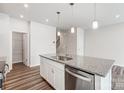 Close up of a spacious kitchen island with granite countertop, stainless steel dishwasher and pendant lights at 2320 Hedgecliff Rd # 158, Kannapolis, NC 28025