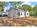 Single-story home with gray siding, black shutters, and inviting covered front porch and yard at 265 Duke Dr, Salisbury, NC 28146