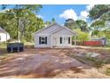 A charming single-story house with light gray siding, dark shutters, and a quaint covered porch at 265 Duke Dr, Salisbury, NC 28146