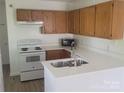 Bright kitchen featuring oak cabinets, white countertops and appliances with a stainless steel faucet at 351 Haigler St, Rock Hill, SC 29732