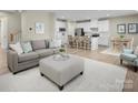 Open concept living room showcasing hardwood floors, a gray sofa, and seamless access to the kitchen at 508 Kenyon Dr, Denver, NC 28037