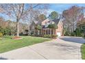 Lovely brick home boasts a well-maintained lawn, mature trees and a side entry three-car garage at 5101 Belicourt Dr, Charlotte, NC 28277