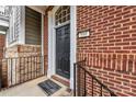 Close-up of a brick house featuring a black door, elegant white trim, and black iron railing at 599 Sixth Baxter Xing, Fort Mill, SC 29708