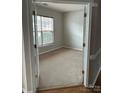 An empty bedroom awaits personalization, featuring neutral carpeting and a bright, sunlit window at 8833 Goldfields Dr, Charlotte, NC 28227