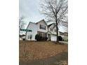 Corner lot two story home features siding and stone details, a two-car garage, and mature trees at 8833 Goldfields Dr, Charlotte, NC 28227