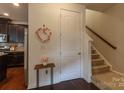 Bright entryway featuring a staircase and view into the kitchen with hardwood floors at 1019 Archibald Ave, Fort Mill, SC 29708