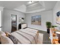 Staged main bedroom featuring a tray ceiling, a double window and ensuite bathroom at 111 Chaffee Pl, Mooresville, NC 28115
