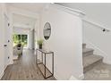 Bright entryway features hardwood floors, a stylish console table, and staircase access to the upper level at 1156 Nations Dr, Charlotte, NC 28217