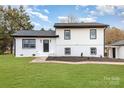 Freshly renovated home with white painted facade, black trim, and an inviting front yard at 1498 Oakridge Farm Hwy, Mooresville, NC 28115