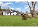 Renovated home with wide, green lawn and new landscaping, and detached two-car garage at 1498 Oakridge Farm Hwy, Mooresville, NC 28115