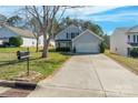 Two-story home with light gray siding, black shutters and long concrete driveway at 1515 Kingdom Way, Indian Land, SC 29707