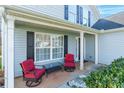 Cozy front porch with rocking chairs, a glass table, and well-maintained landscaping at 1515 Kingdom Way, Indian Land, SC 29707
