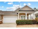 A tan home with a two-car garage, well-kept lawn, and a covered front porch at 2036 Hudson Ln, Fort Mill, SC 29707