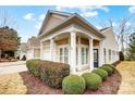 A charming home with covered entry, showcasing neatly trimmed hedges, and beige siding with white trim at 2036 Hudson Ln, Fort Mill, SC 29707