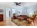 Inviting living room boasting hardwood floors, a leather sofa set, and sunlit windows with white shutters at 2036 Hudson Ln, Fort Mill, SC 29707