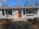 Charming home featuring neutral brick, black shutters, window boxes, and a brightly colored door at 21248 Ravenwood Rd, Albemarle, NC 28001