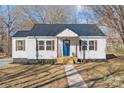 Beautiful white home with a dark metal roof, wood accents and a bright blue door with welcoming decor at 312 Motz Ave, Lincolnton, NC 28092