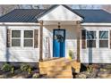 Close up of the entrance with a bright blue door and 'WELCOME' sign adds to this cozy home's curb appeal at 312 Motz Ave, Lincolnton, NC 28092