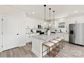 Stylish kitchen with white cabinets, granite counters, stainless appliances, an island, and bar stool seating at 6117 Grove Park Blvd, Charlotte, NC 28215