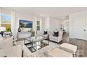 Inviting living room showcasing neutral furniture, large windows, and a stylish glass coffee table at 6117 Grove Park Blvd, Charlotte, NC 28215